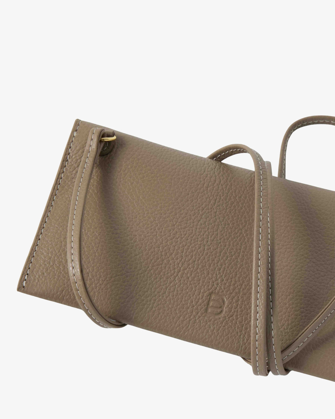 A close-up of a taupe pebbled leather handbag showing the side profile, top handle, and a small debossed logo on a light gray background.
