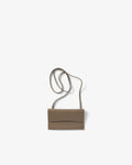 A taupe leather crossbody bag, shown against a white, plain background.