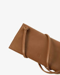 A close-up of a brown pebbled leather clutch or wallet-style handbag with a matching strap, shown on a plain light gray background.