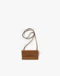 A small tan leather crossbody bag with a long thin strap, shown against a plain light gray background.