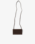 A dark brown leather crossbody bag with a long, thin strap, shown flat against a light gray background.