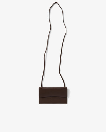 A dark brown leather crossbody bag with a long, thin strap, shown flat against a light gray background.