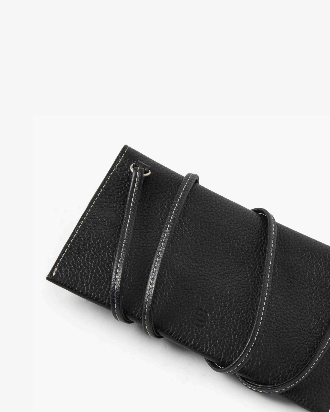A close-up of a black pebbled leather accessory, likely a pouch or sleeve, featuring a strap with white contrast stitching and a small embossed logo on a clean white background.