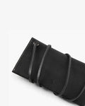 A close-up of a black pebbled leather accessory, likely a pouch or sleeve, featuring a strap with white contrast stitching and a small embossed logo on a clean white background.