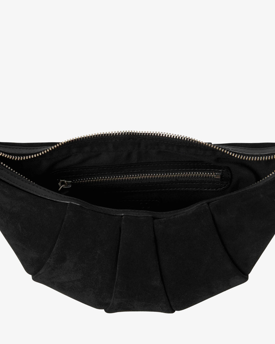 Close-up of the interior of a black pleated suede bag, showing a zippered compartment with a silver-tone zipper pull against a light gray background.
