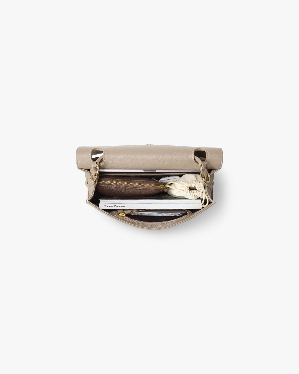 A beige leather zippered briefcase shown open from a top-down view, revealing a silver metal lunchbox, a black circular item, and other small accessories inside, set against a plain white background.