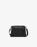 Black leather handbag with gold hardware and a detachable cross body strap, shown from the back in front of a white background. 