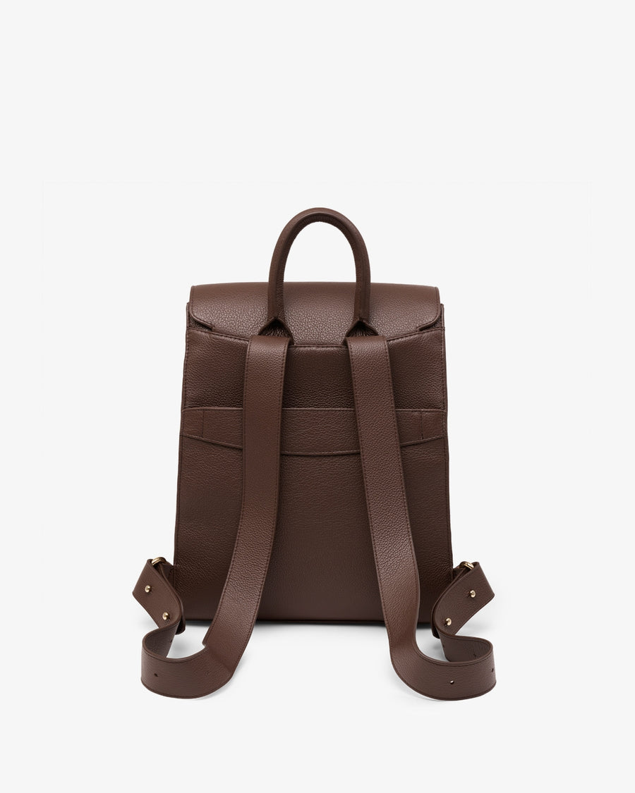 A dark brown leather backpack shown from the back, featuring a top handle and adjustable shoulder straps with metal hardware, set against a plain light gray background.