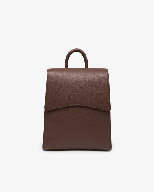 A brown textured leather backpack with a top handle, shown against a plain white background.