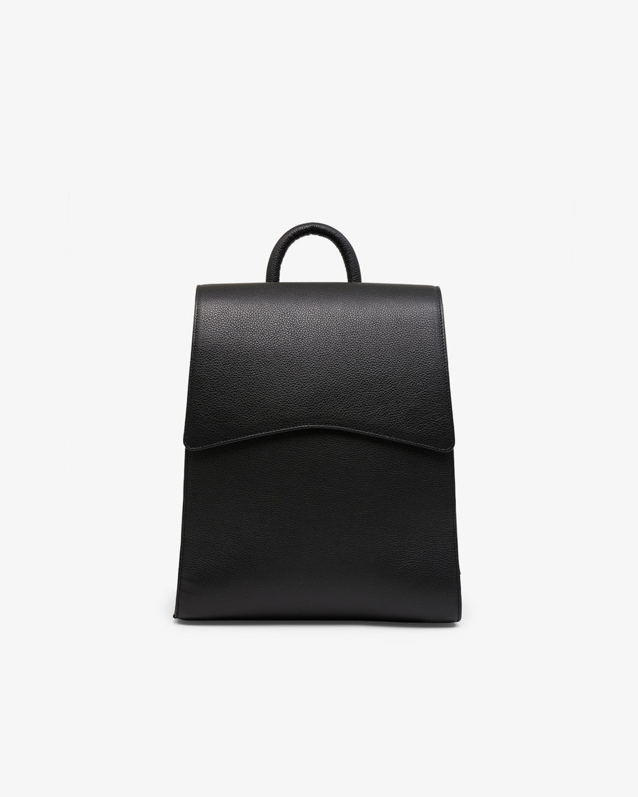 A minimalist black leather backpack with a top handle, shown from the front against a clean white background.