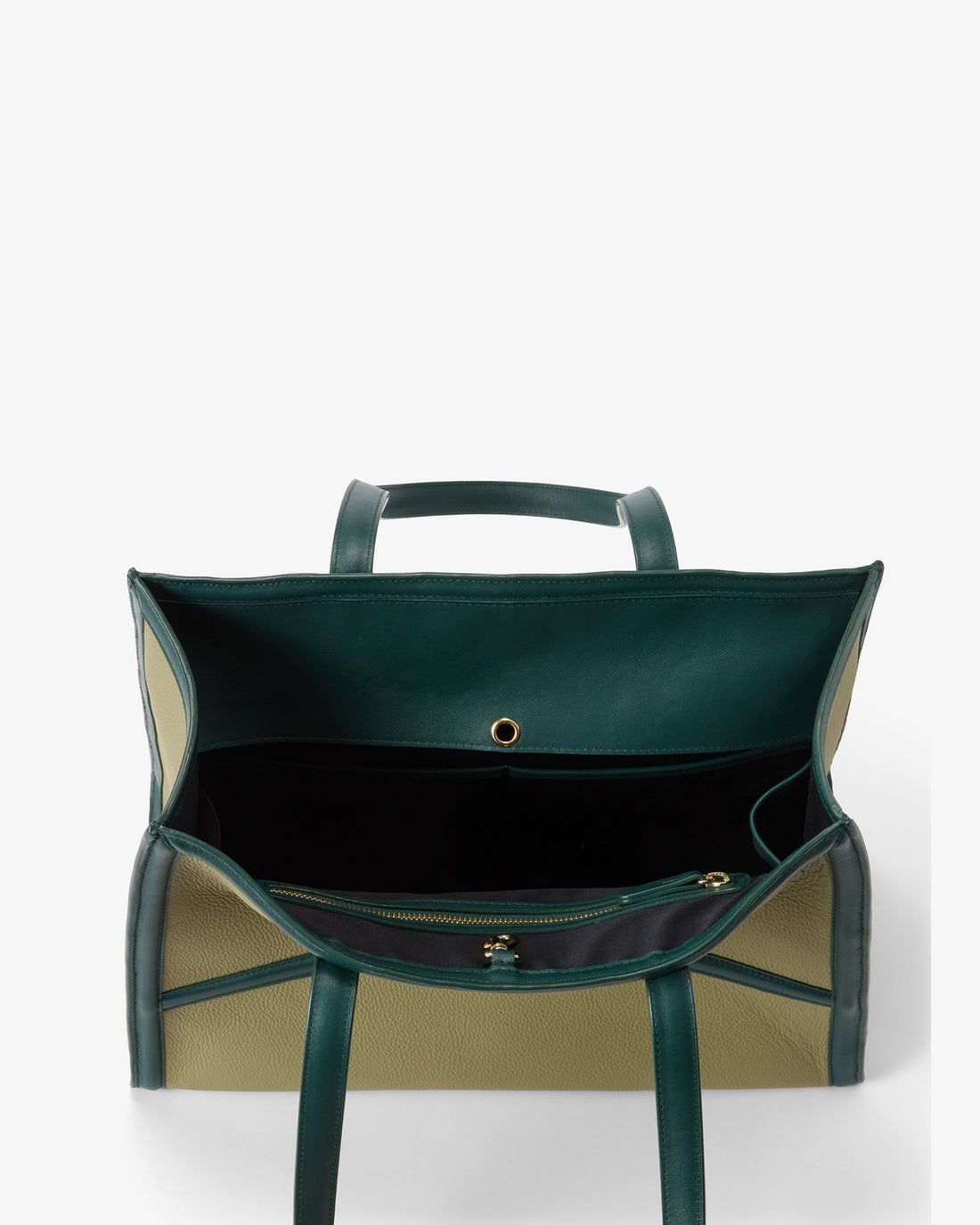 An open dark green leather tote bag with beige panels, shown from the back against a light gray background.