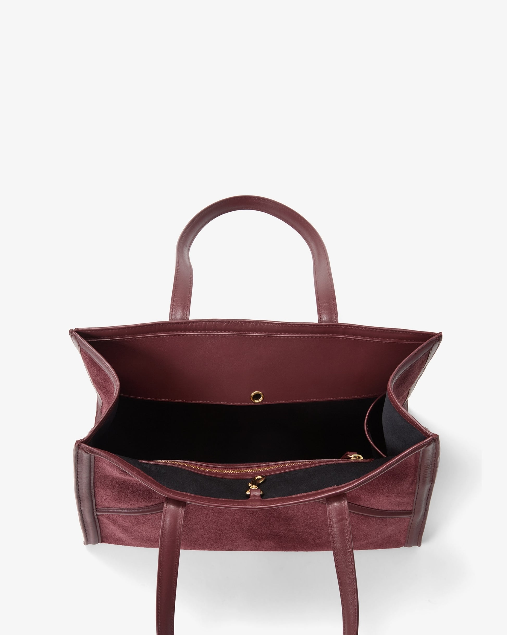 A top-down view of a burgundy leather tote bag with a black interior lining and gold-tone hardware, set against a plain white background.