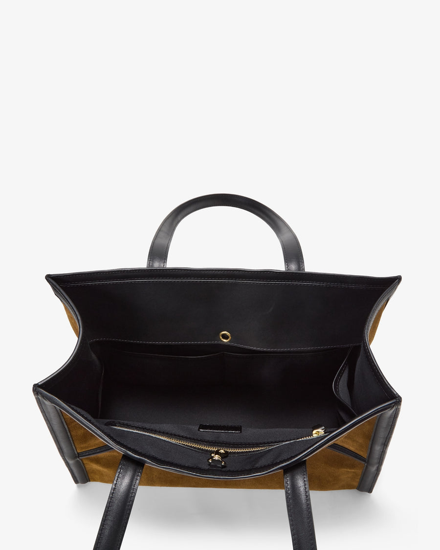 An overhead view of a structured tote bag with a black interior lining, black leather handles, and tan and black striped exterior panels, shown against a plain white background.
