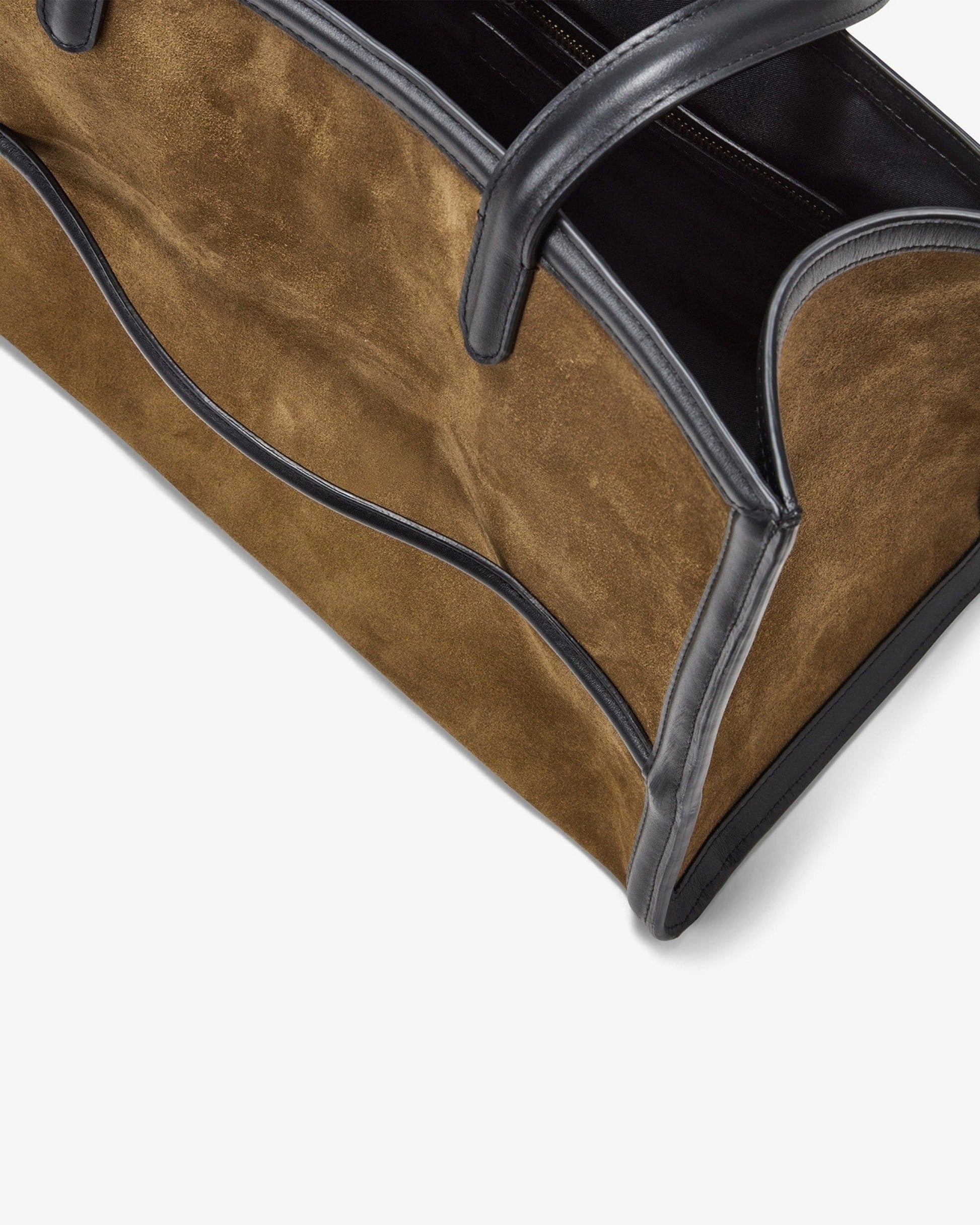 Close-up of a brown suede tote bag with black leather trim and handles, shown on a clean white background.