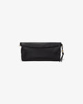 A black leather clutch bag with a flap closure and a small tassel detail as well as a luggage strap, shown against a plain light gray background.