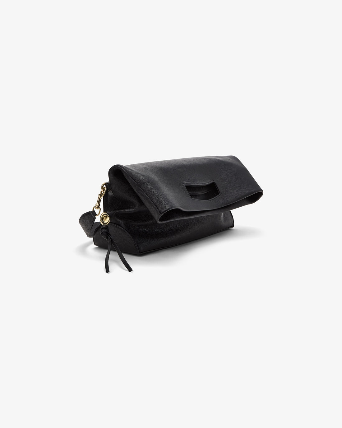 A black soft leather tote, folded on a white surface. A shoulder strap and a metal detail is attached to the bag.