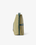 A structured leather bucket bag in sage green and teal, featuring a vertical strap closure with gold-tone hardware, photographed against a clean white background.