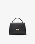 A structured black leather handbag with a top handle and a small gold-tone metal accent on the front, photographed against a clean white background.