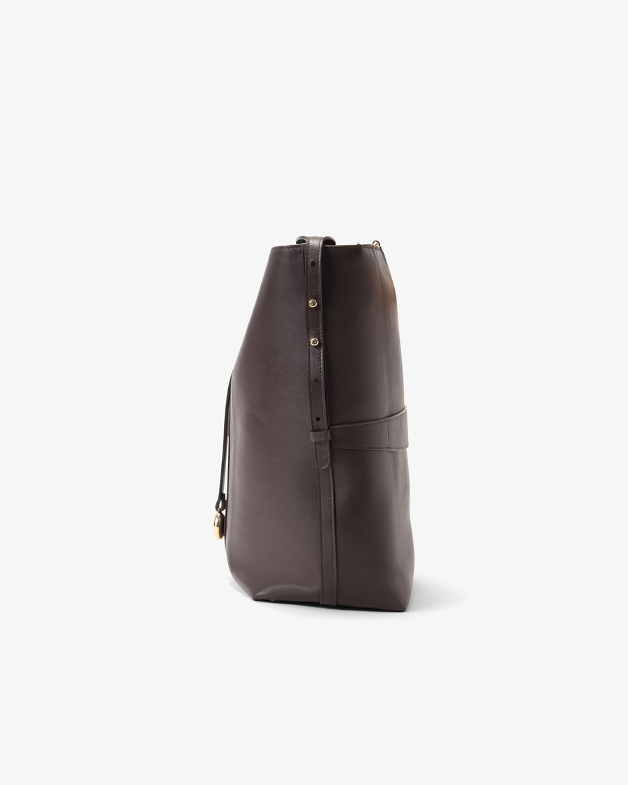 A dark brown leather bucket bag shown from a side profile view against a clean, light gray background.