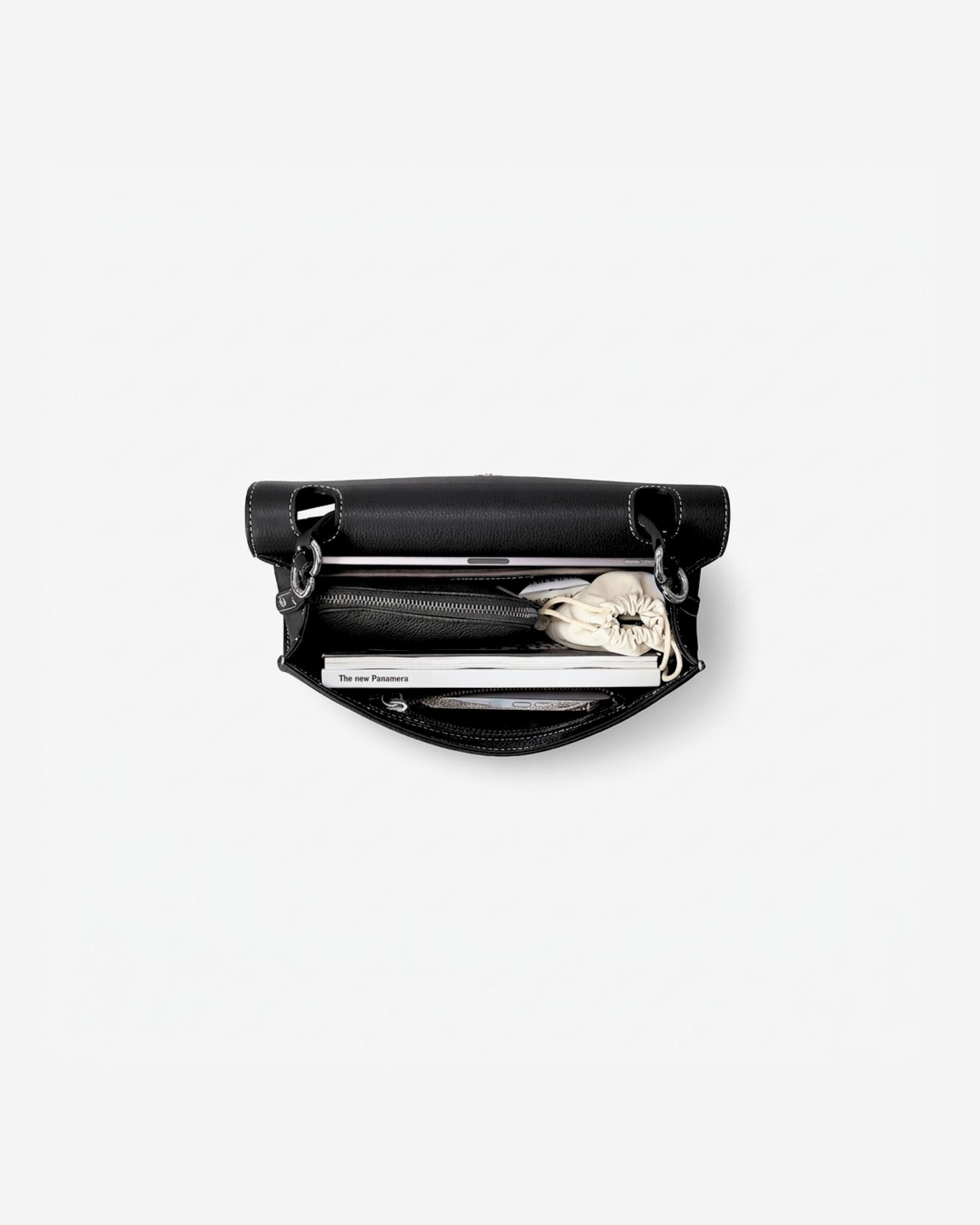 A black leather zippered briefcase shown open from a top-down view, revealing an iPad, a cable pocket and other small accessories inside, set against a plain white background.