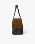 A structured duffel bag with a two-tone color-blocked design, featuring a brown suede upper section and a black leather lower section and shoulder strap, shown against a plain light gray background.