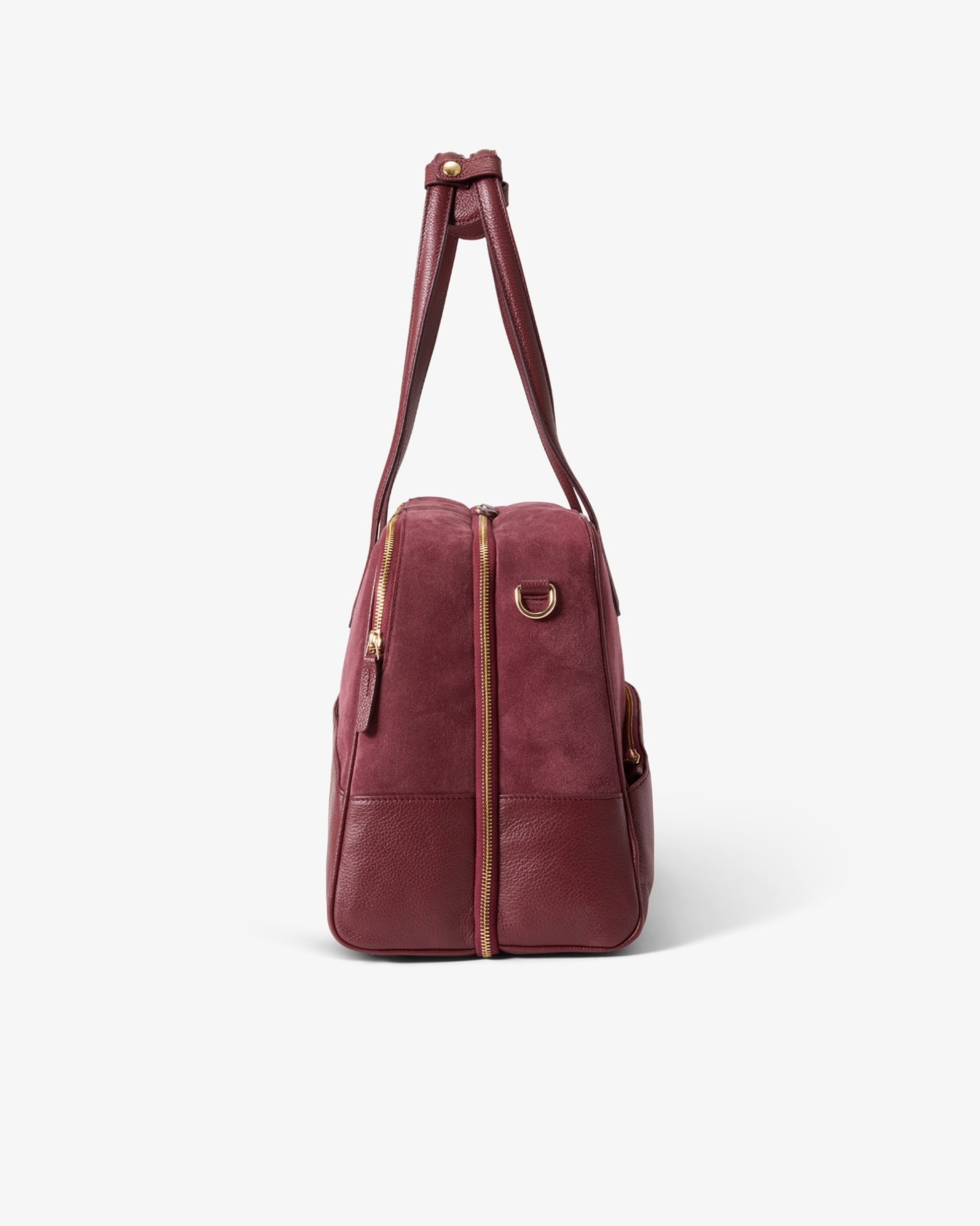 A burgundy leather duffel bag with gold-tone hardware, shown from the side on a clean white background.