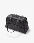 A black crocodile-embossed leather duffel bag with dual top handles and a zippered main compartment, shown on a light gray background.