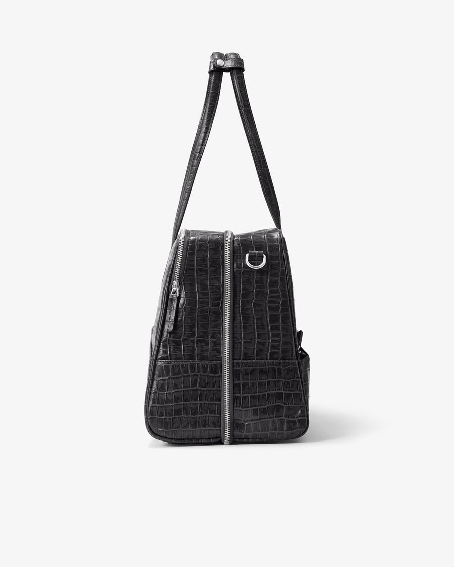 A black crocodile-embossed leather shoulder bag with a front zipper closure and silver-tone hardware, shown against a plain light gray background.