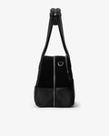 A black shoulder bag with a black suede upper body, black leather lower front pocket, and a black shoulder strap, shown against a plain white background.