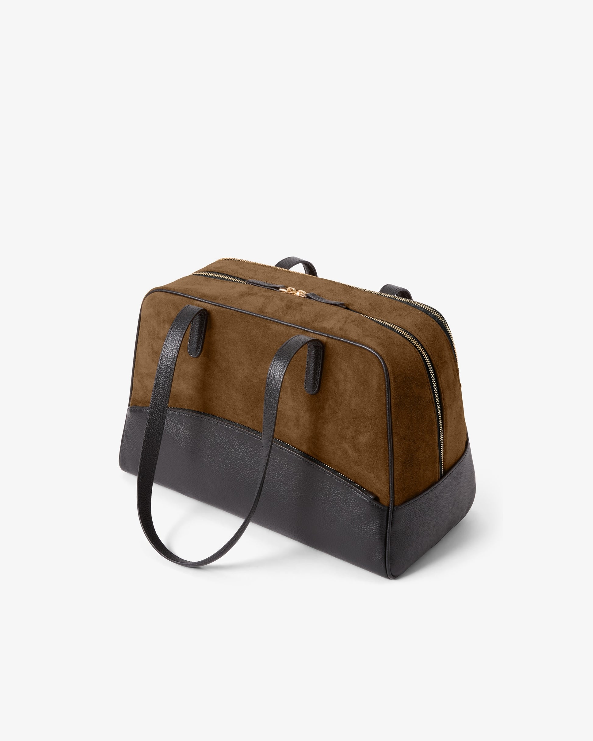 A brown and black color-blocked duffel bag made of suede and leather, featuring dual top handles and a long shoulder strap, photographed on a clean white background.
