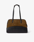 A structured handbag with a color-blocked design, featuring a brown suede upper section, a black textured lower section, a luggage strap, and black leather shoulder straps, shown against a plain white background.