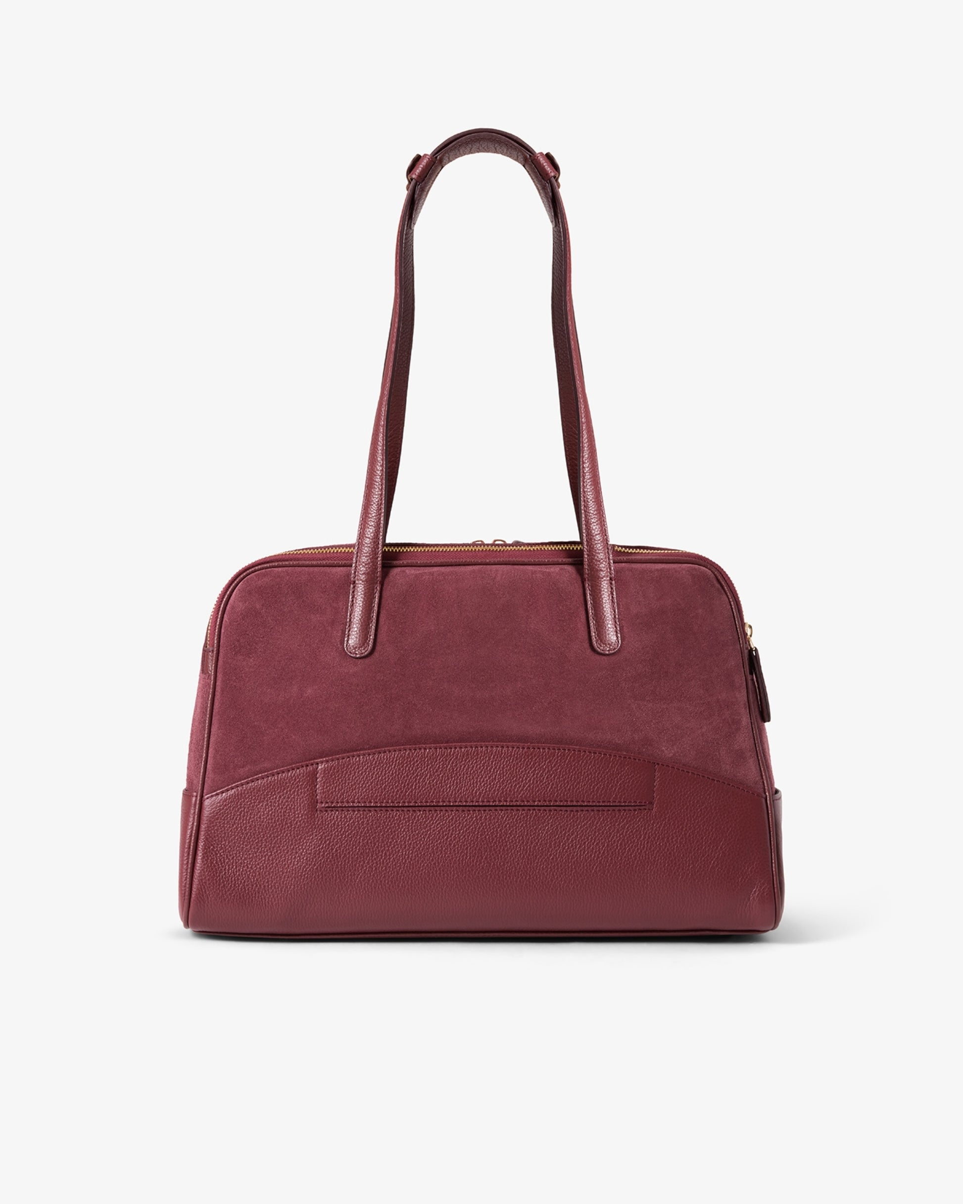 A burgundy leather handbag with dual top handles and a front slip pocket, as well as a luggage strap, photographed against a clean white background.
