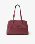 A burgundy leather duffel bag with dual top handles and a front zippered pocket, shown against a plain white background.