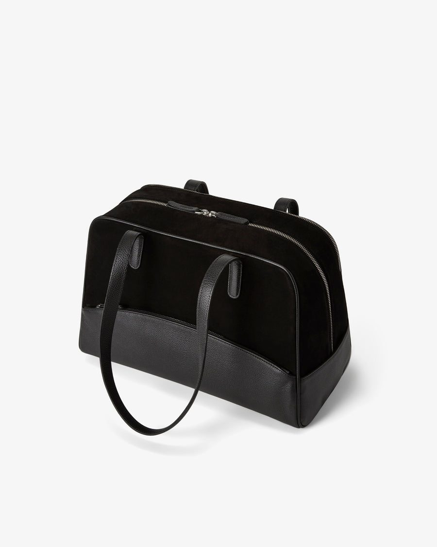 A structured black leather bag with dual top handles and a top zipper closure, photographed on a clean white background.