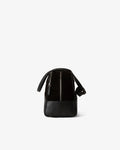 A black leather shoulder bag with a structured rectangular shape, featuring a vertical zippered pocket on the side and a small black leather pad attached on the straps, shown against a plain white background.