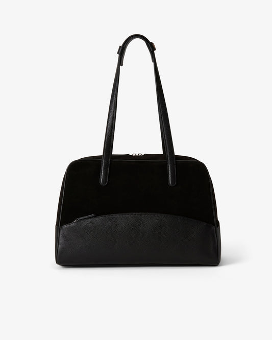 A black shoulder bag with a smooth leather base, a black suede upper section, and dual top handles, shown against a plain light gray background.