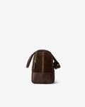 A dark brown leather duffel bag with a vertical zippered compartment and two top handle, shown from the back on a light gray background.