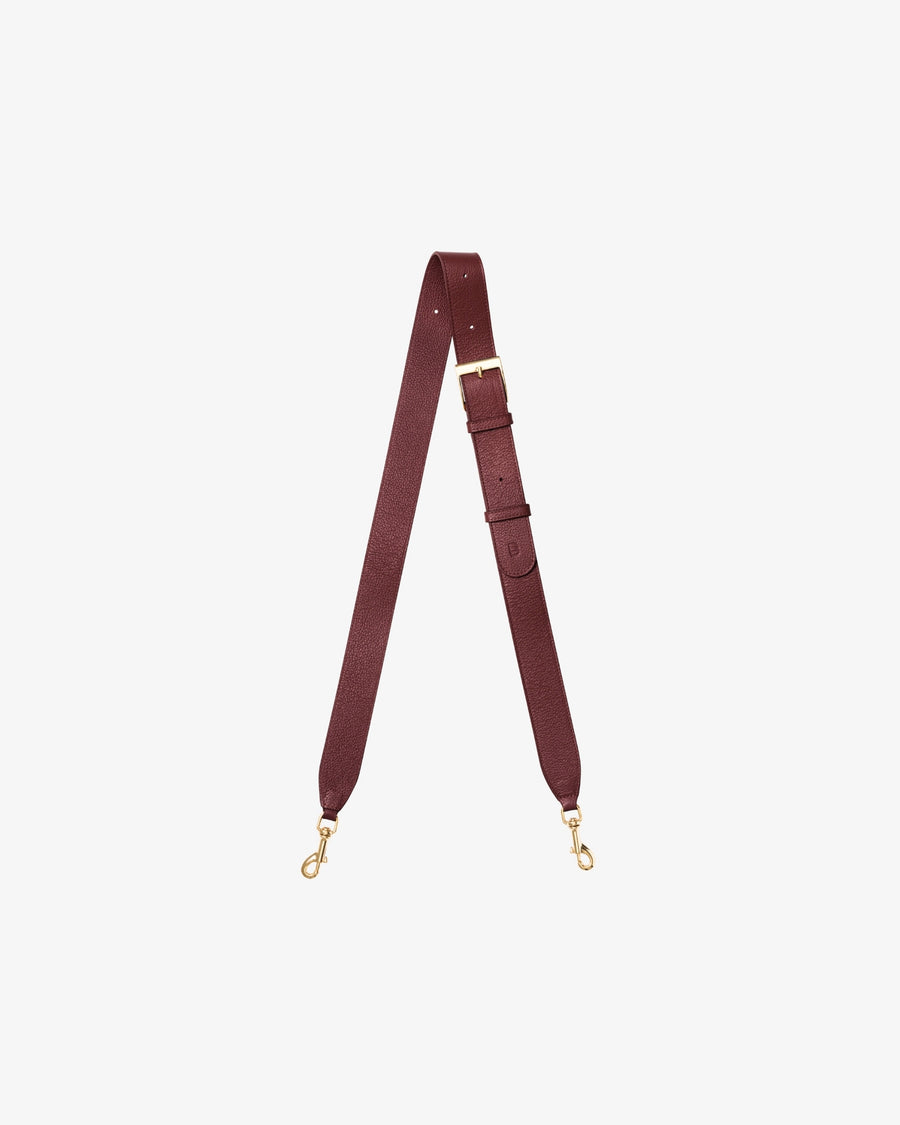 A burgundy leather shoulder strap with gold-tone metal hardware, including a buckle, adjustment loops, and two swivel snap hooks, displayed on a light gray background.