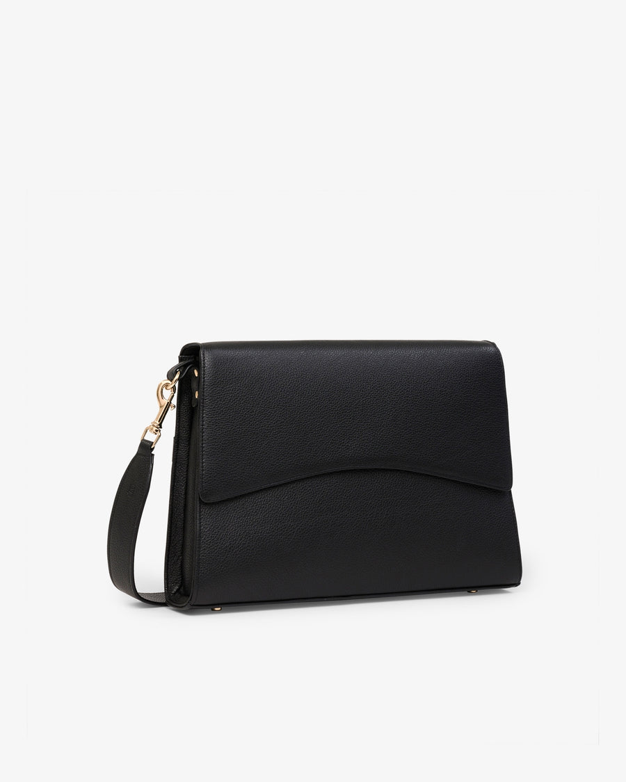 A black leather shoulder bag with a curved flap and a gold-tone zipper pull, shown on a plain light gray background.