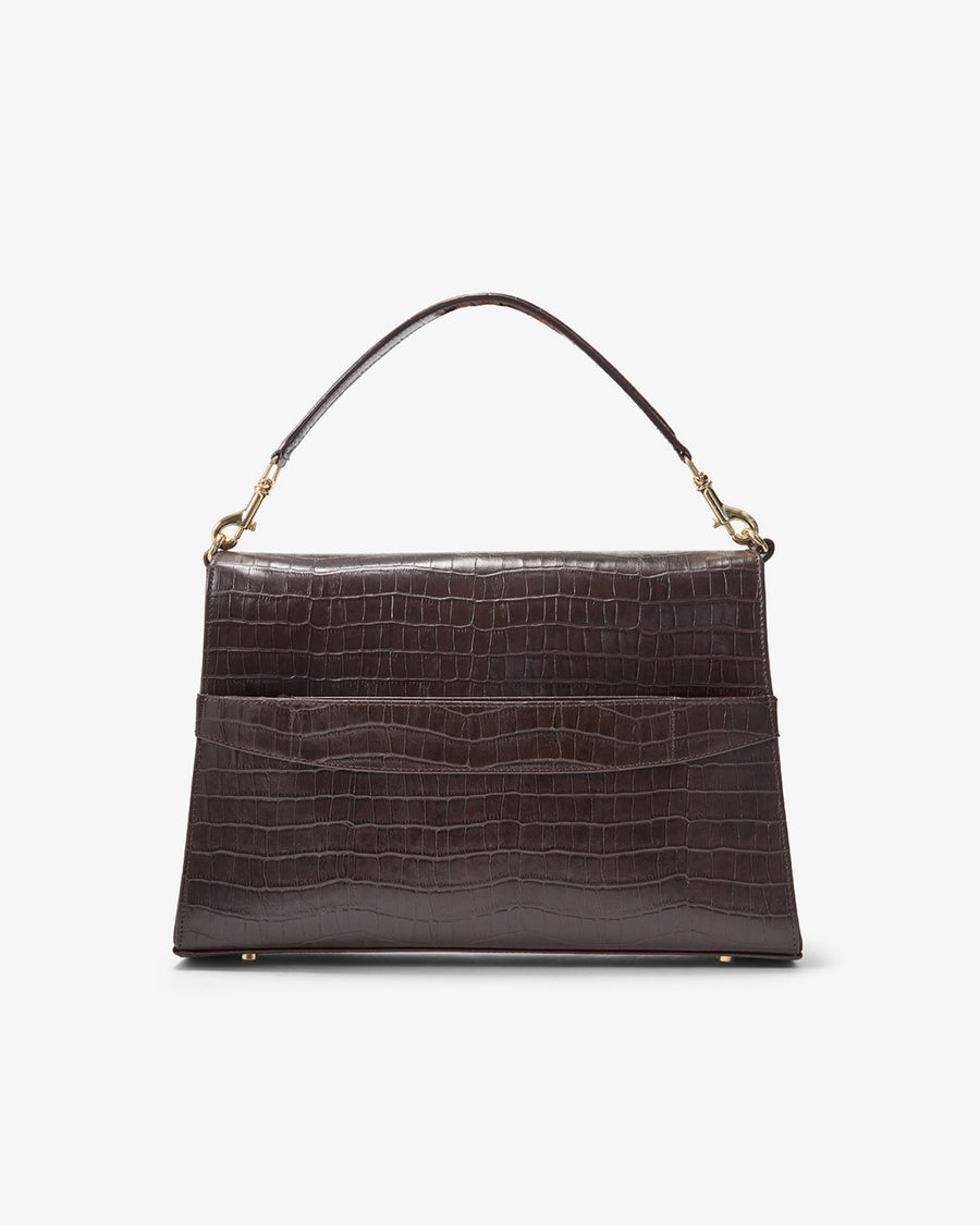 A dark brown crocodile-embossed leather handbag with a single top handle and gold-tone hardware, featuring a luggage strap, shown against a plain white background.