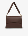 A dark brown leather shoulder bag with a flap front, curved lower edge, and a matching adjustable shoulder strap with gold-tone hardware, shown on a light gray background.