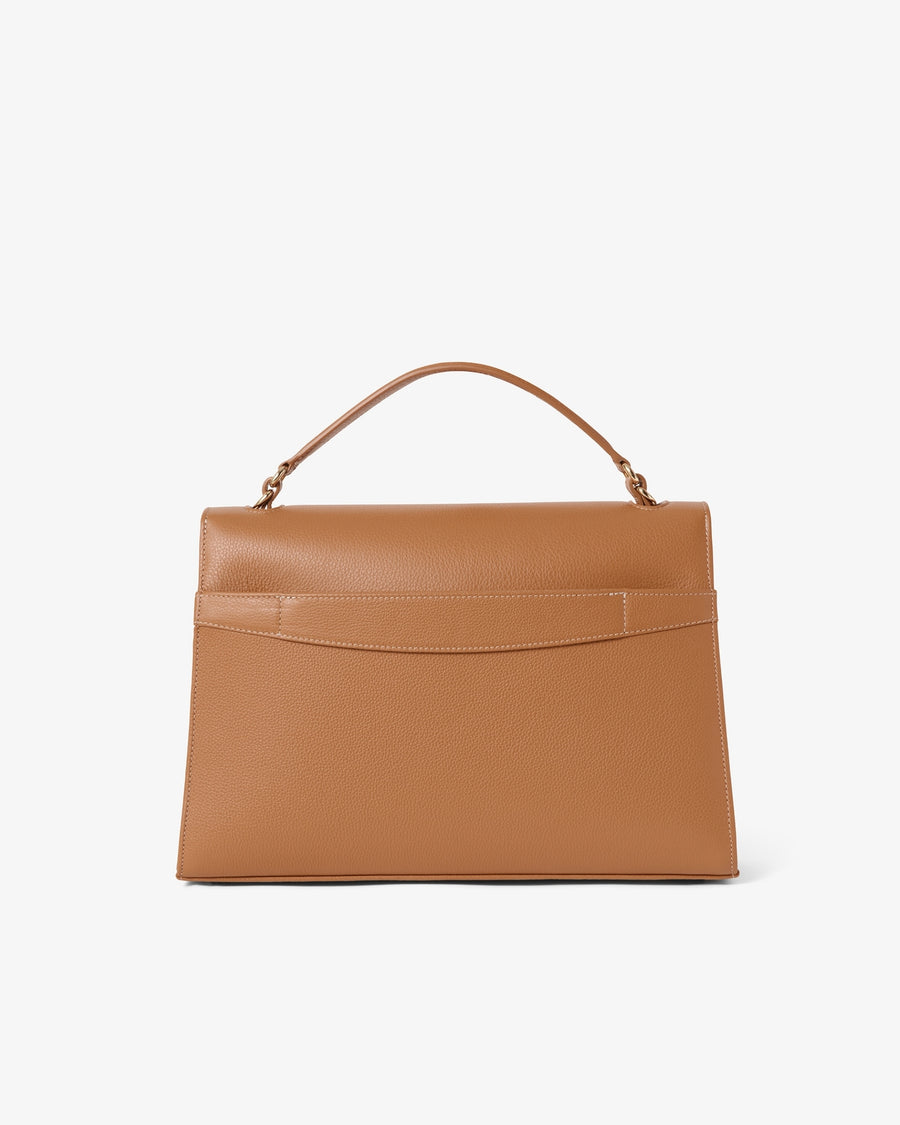 A structured tan leather handbag with a top handle and a luggage strap, shown from the back against a clean white background.
