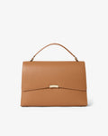 A structured tan leather handbag with a top handle and a gold-tone metal accent on the front flap, shown against a plain white background.