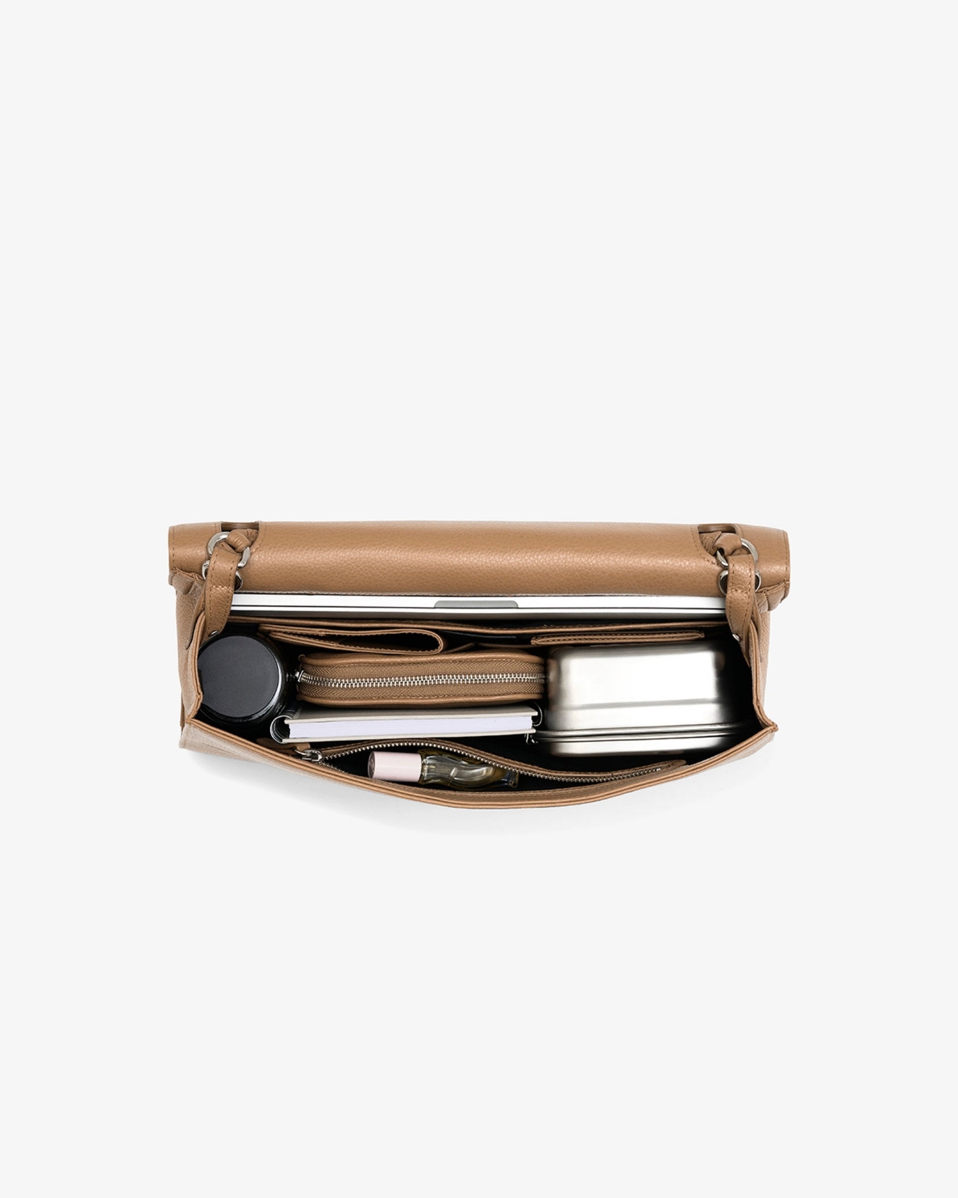 A tan leather bag shown open, revealing a set of travel accessories inside, including a silver metal flask, a small zippered pouch, and other items, on a light gray background.