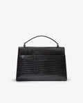 A structured black handbag with an embossed crocodile pattern, featuring a top handle and a luggage strap, shown from the back against a plain light gray background.