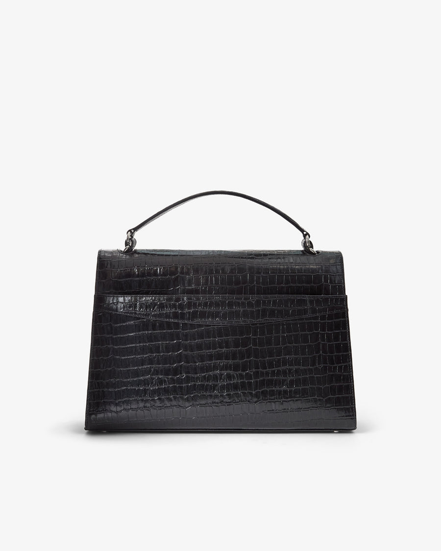 A structured black handbag with an embossed crocodile pattern, featuring a top handle and a luggage strap, shown from the back against a plain light gray background.