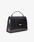 A black crocodile-embossed leather handbag with a top handle and a small silver metal accent on the front, shown against a plain white background.