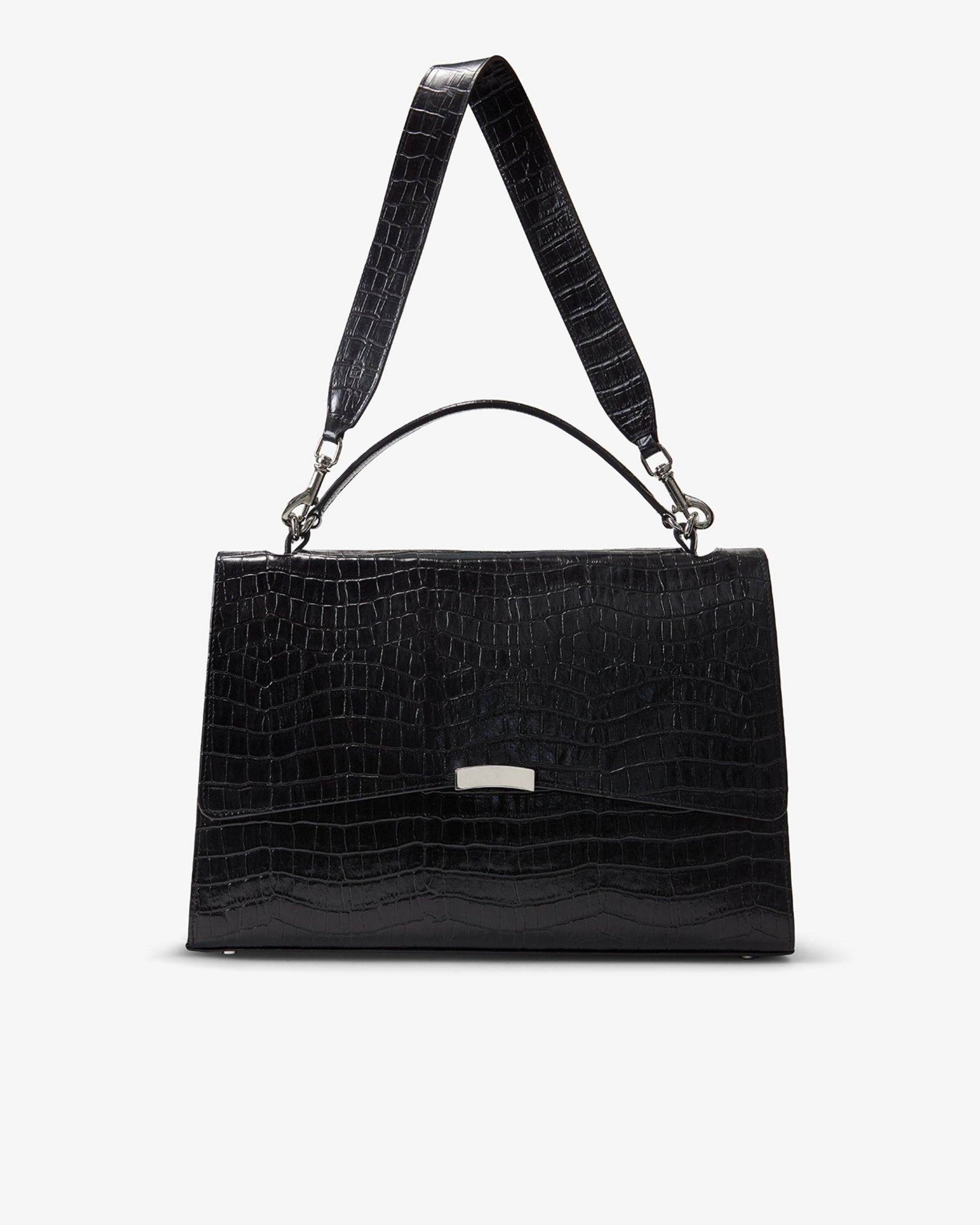 A black crocodile-embossed leather handbag with a top handle and shoulder strap, featuring a small silver metal accent on the front, set against a plain light gray background.