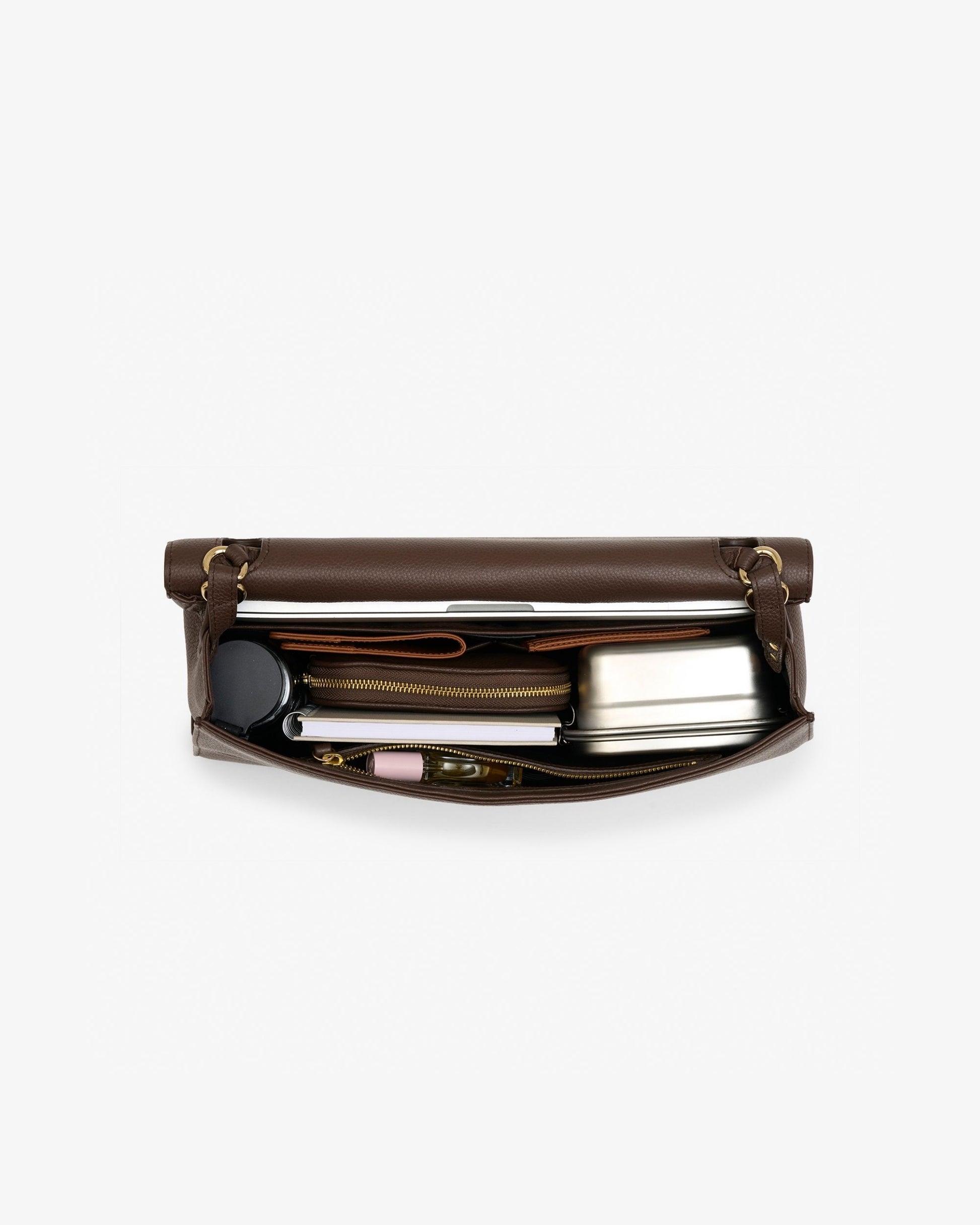 A dark brown leather briefcase shown open, revealing its interior storage compartments filled with travel accessories like a metal tin, notebook, and small items, set against a plain light gray background.