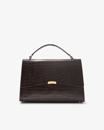 A dark brown crocodile-embossed leather handbag with a top handle and a gold-tone clasp, shown against a plain white background.